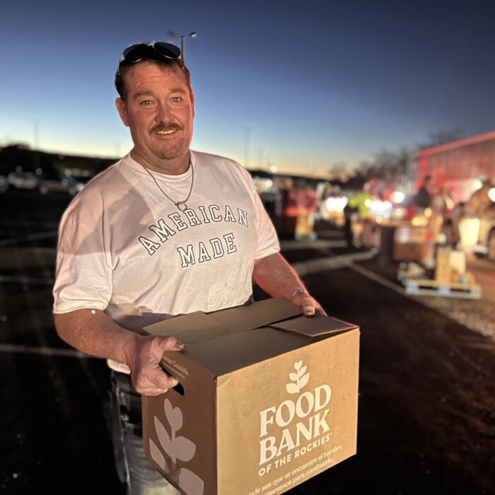 a man holding a box of food outside.