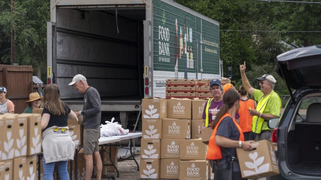 Volunteers surrounded by food and boxes at a mobile pantry distribution.