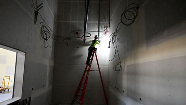 construction worker on top of a ladder in a dark hallway