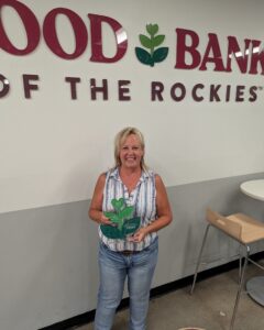 LaDonna standing in front of a Food Bank of the Rockies sign