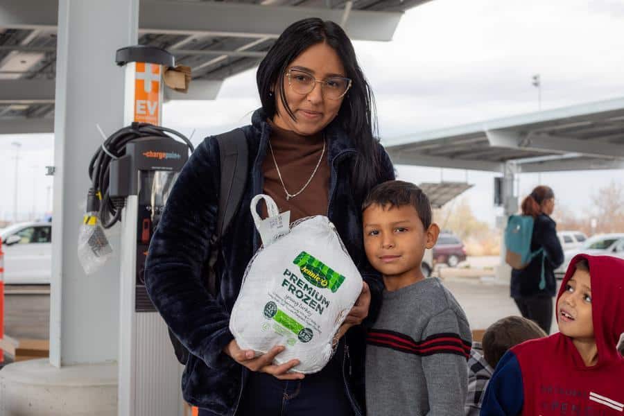 a woman and child holding a bag of food