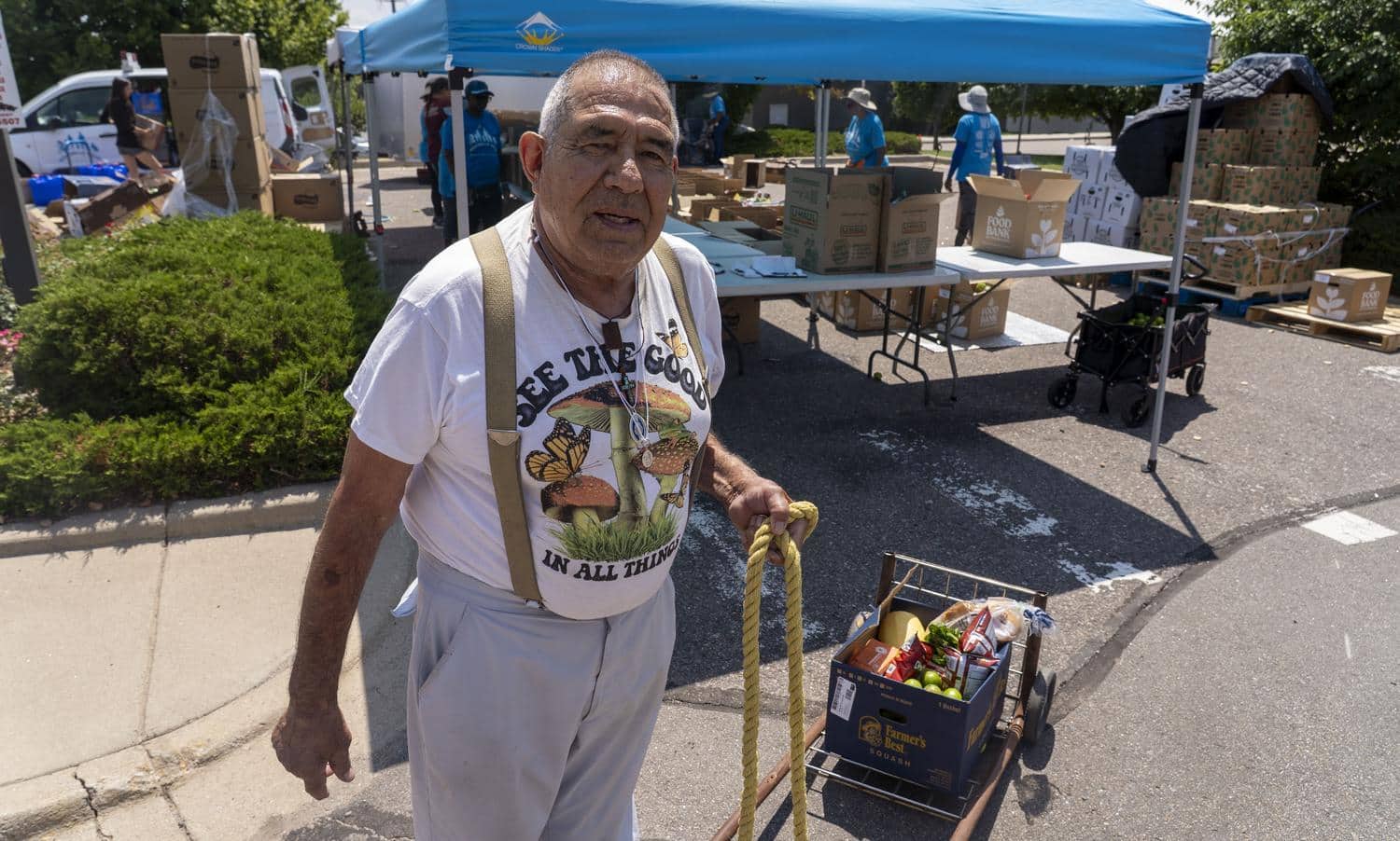 Man holding cart of food.