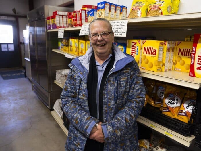 a woman standing in front of shelves filled with food
