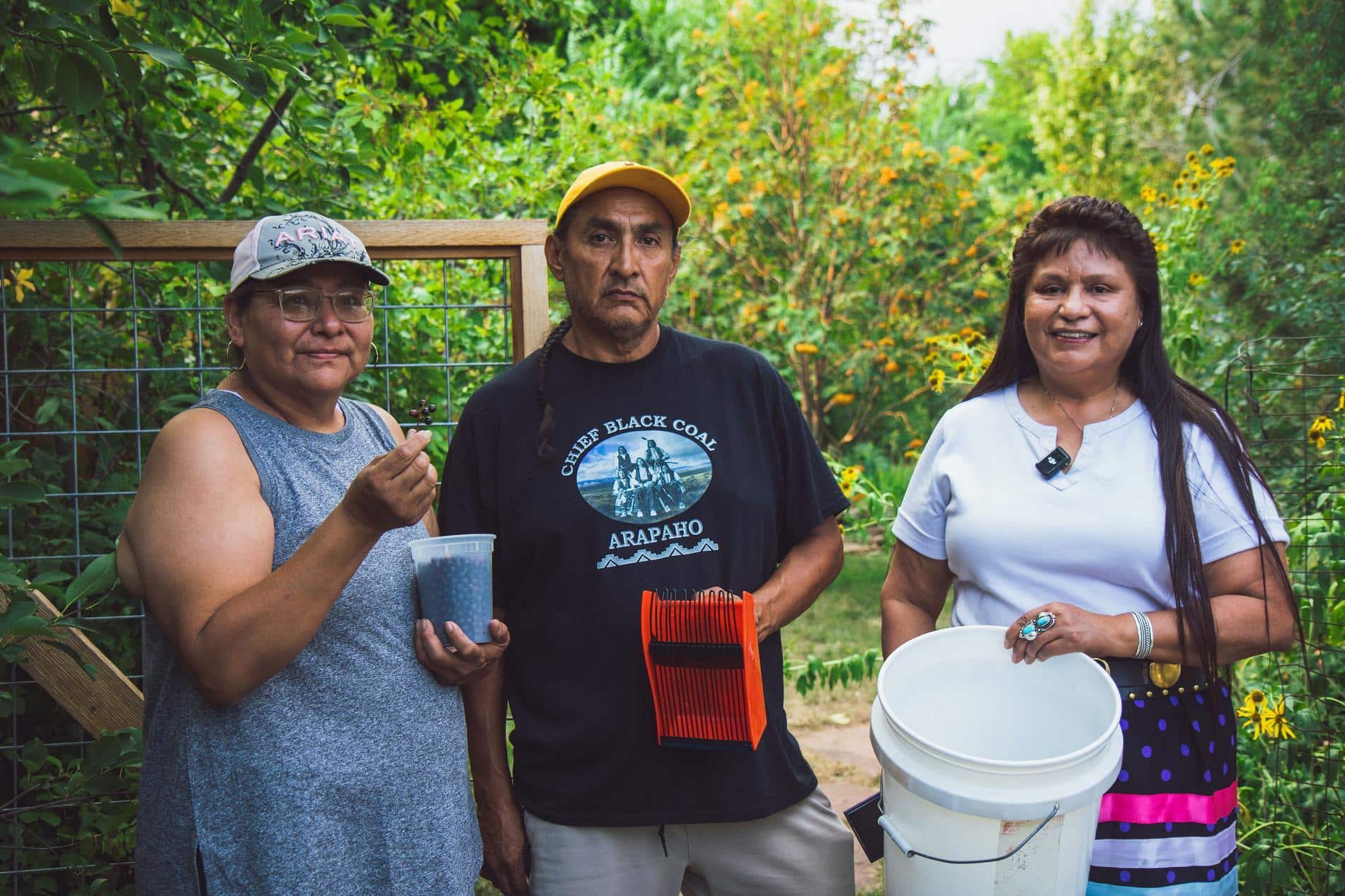 Workers pose showing the chokecherries picked.