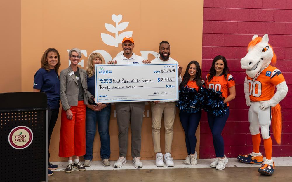 Broncos and Cigna holding a large check for $20,000.