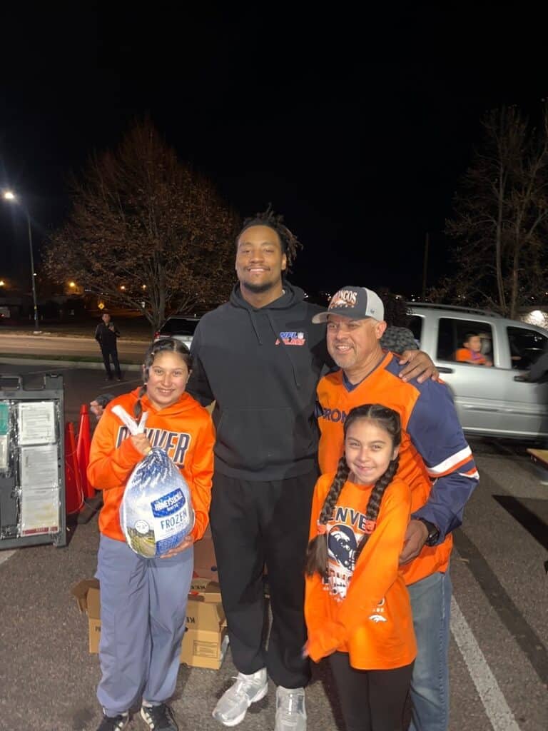 Nik Bonitto with a family at a food distribution.