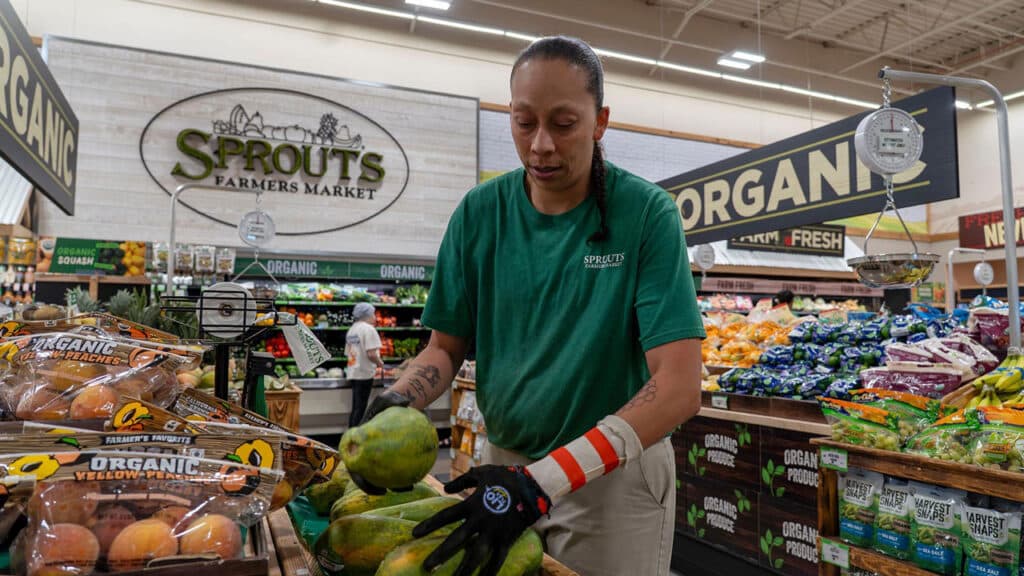 A Sprouts employee stocking fresh produce