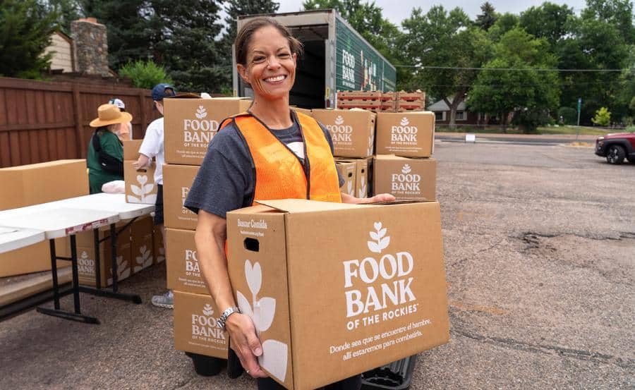 a person holding a Food Bank of The Rockies food box outside