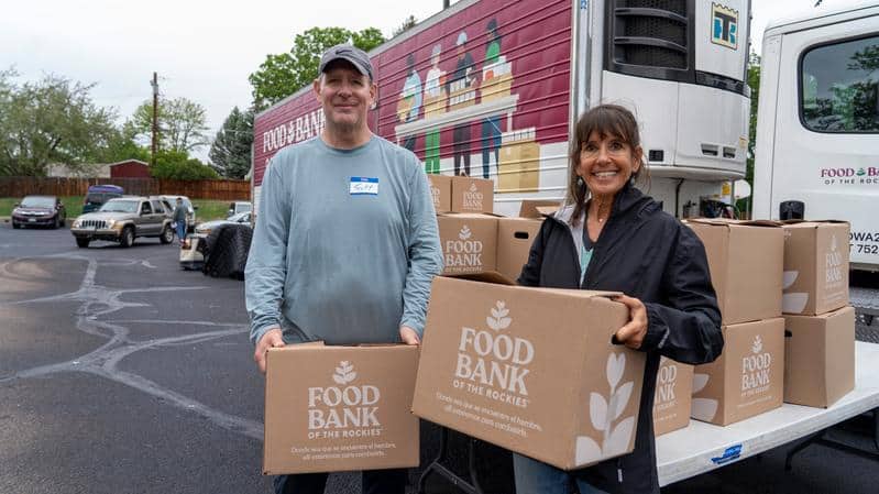 2 people holding boxes of food at the St. James Presbyterian Mobile Pantry